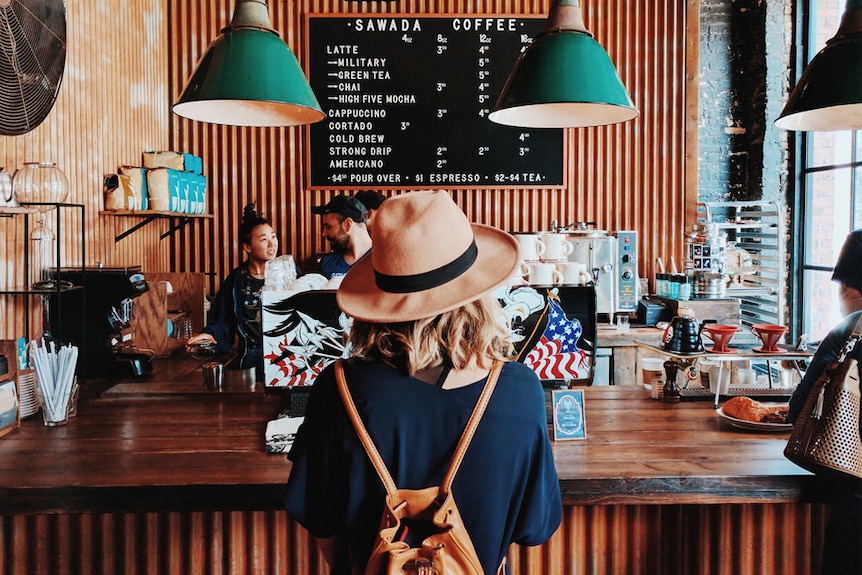 A woman waits to be served at a coffee shop.