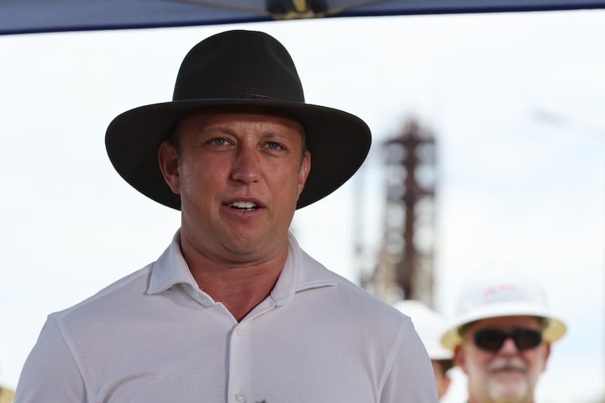 Queensland Deputy Premier Steven Miles wearing a hat and speaking at Ampol oil refinery at Lytton