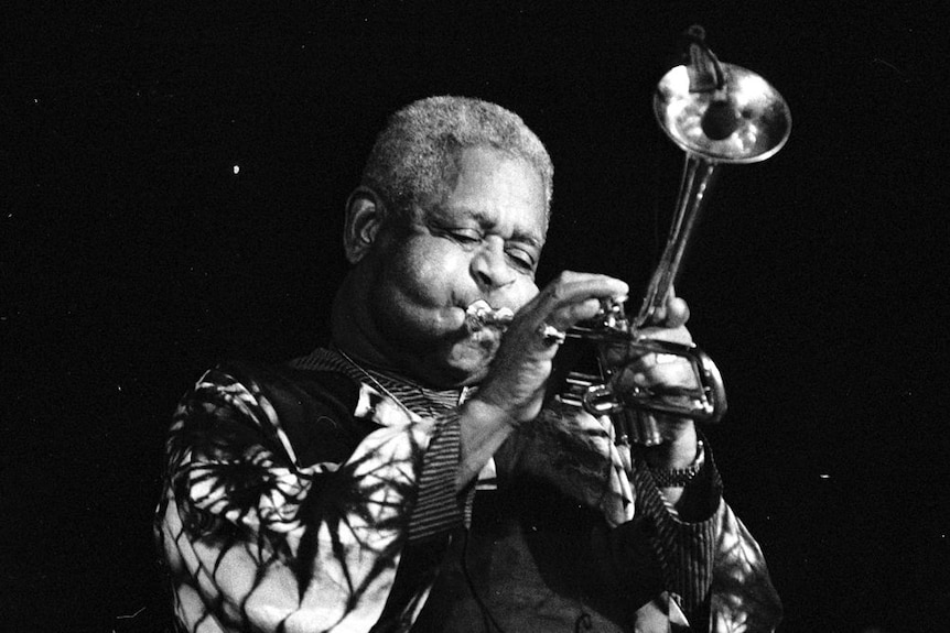 Black-and-white photo of Dizzy Gillespie playing his bent trumpet