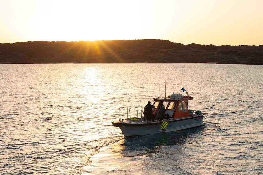 The dive boat is pictured on sunset departing from the support vessel and heading home for the day