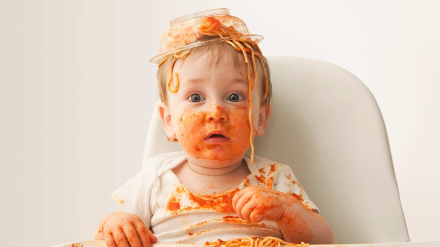 Baby boy eating spaghetti