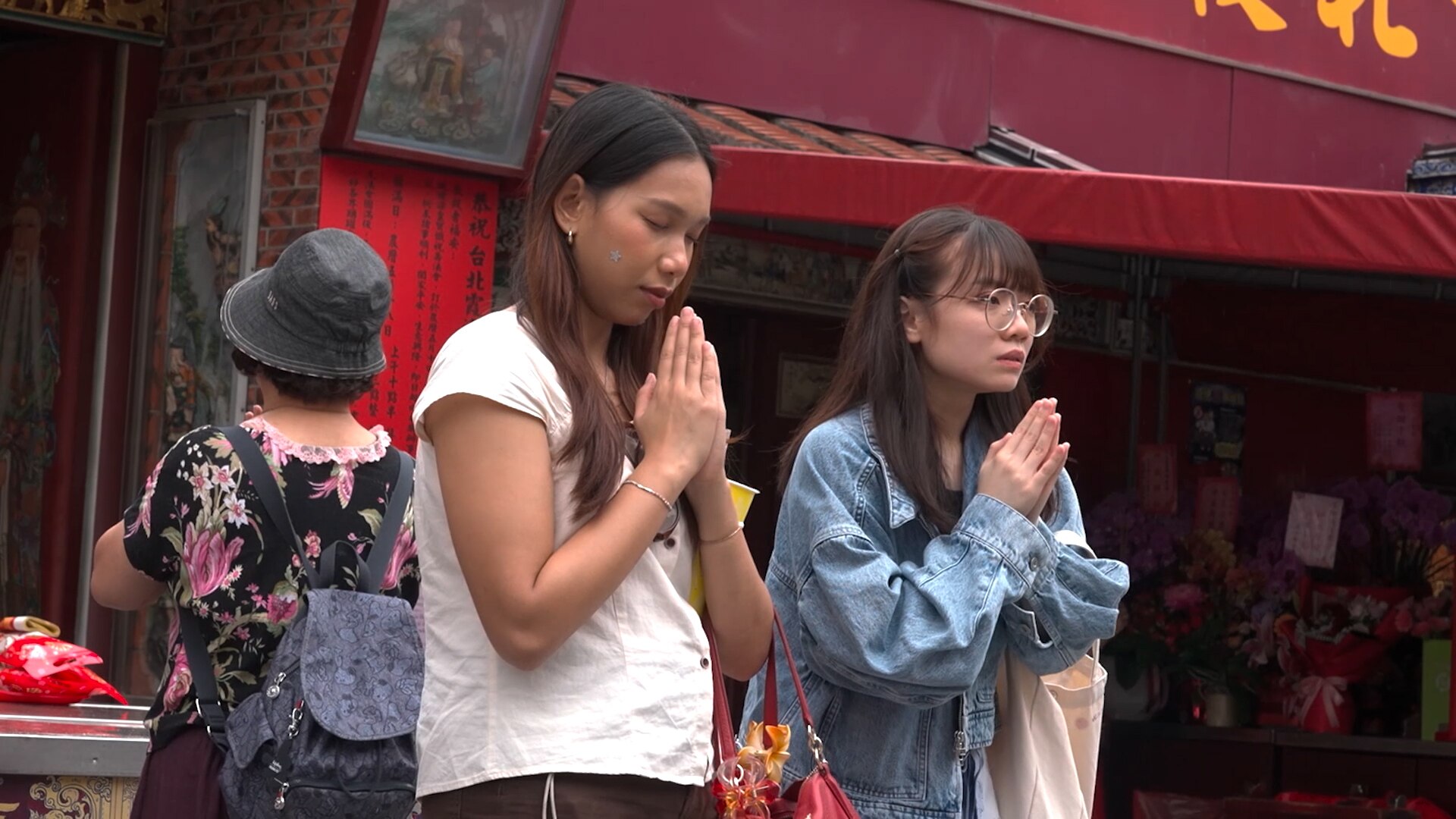 Two young Taiwanese women praying.