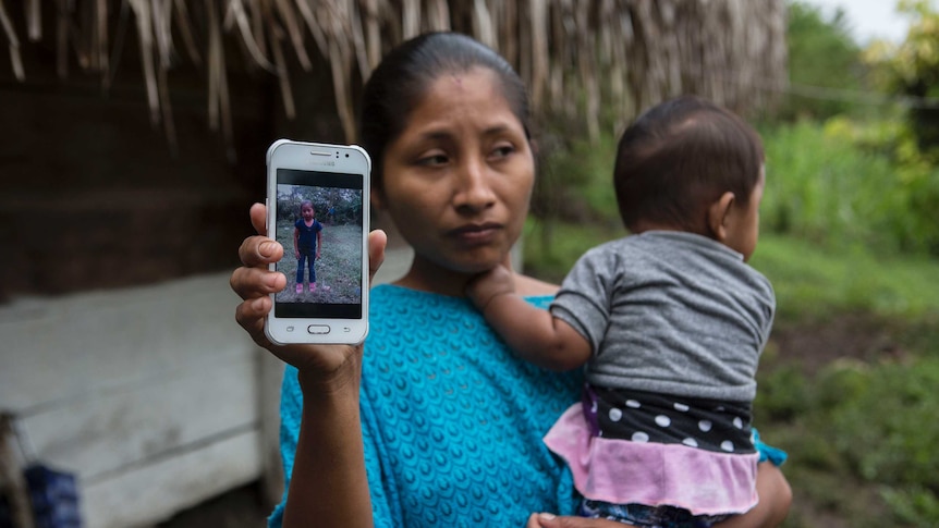 Claudia Maquin, mother of dead Guatemalan migrant, Jakelin Caal Maquin holds a photo of her daughter on her phone.