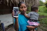 Claudia Maquin, mother of dead Guatemalan migrant, Jakelin Caal Maquin holds a photo of her daughter on her phone.
