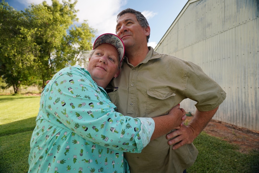 Woman in blue shirt and man in green shirt staring into distance