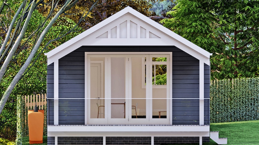 A small blue and white home sit in a green backyard. it has open white french doors.