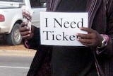 A scalper sells tickets outside a venue