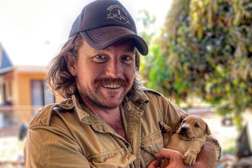 A vet holding a tiny puppy.