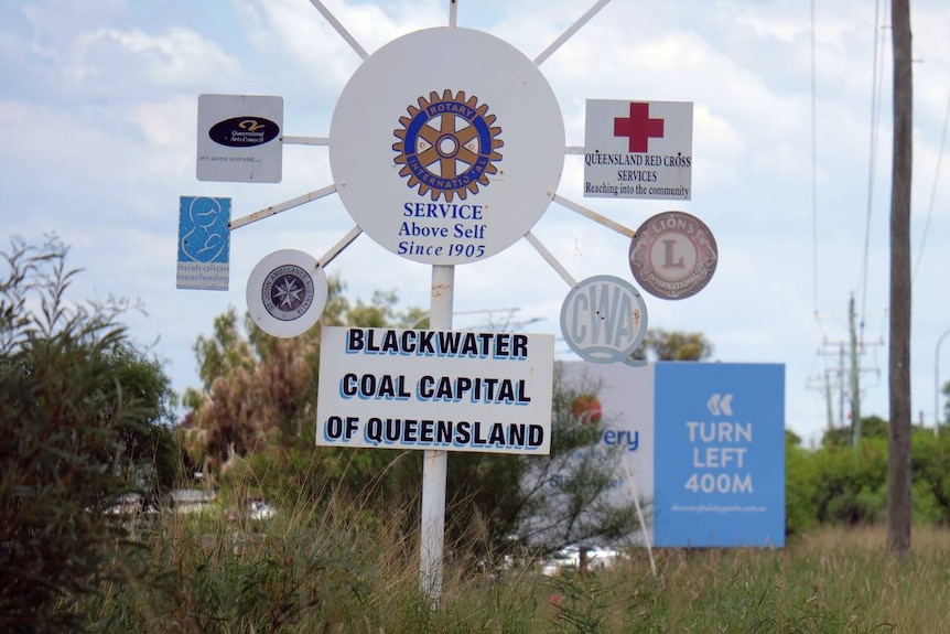 a group of signs at the entry of blackwater, queensland. One says "blackwater coal captial of queensland"