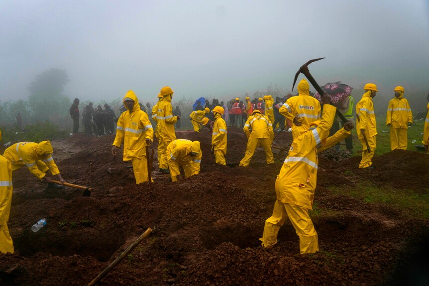 Rescuers dig graves to bury the bodies of victims at the site of a landslide in India. 