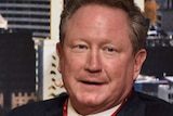 A mid shot of Andrew Forrest wearing a suit and tie with a lanyard around his neck.