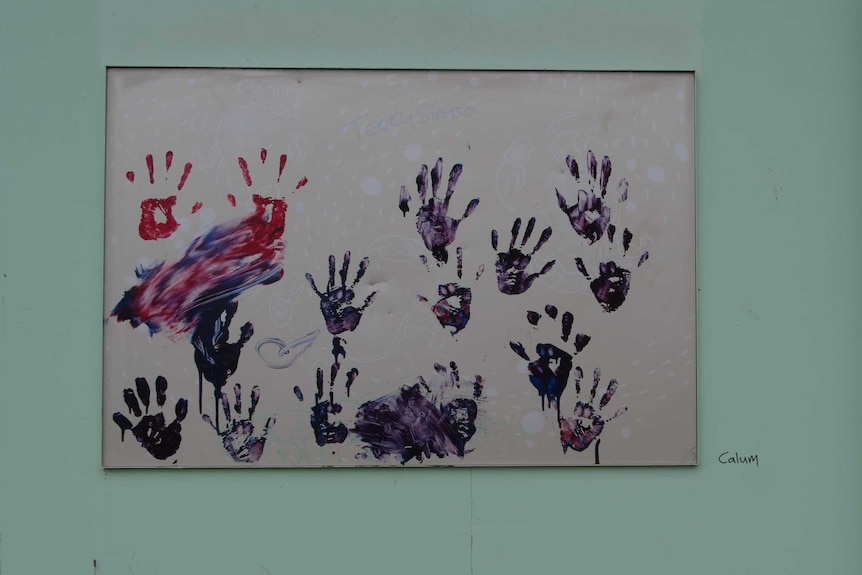 Blue and red hands achieved with paint on a poster stuck to a building