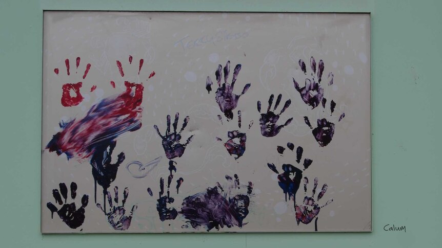 Blue and red hands achieved with paint on a poster stuck to a building