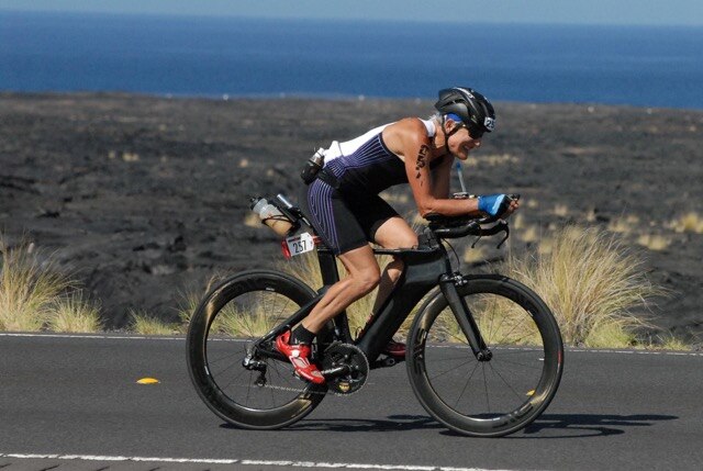 Kara McKinlay riding through lava fields at the Kona 2014 IronMan World Championships.
