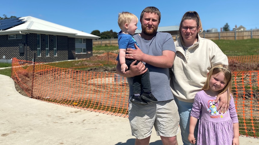 David and Bronwyn Barber with their children in a front yard.