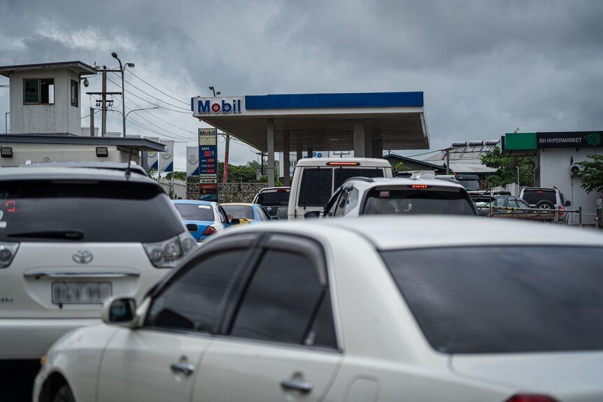 Two lines of cars stopped as they head towards a Mobil petrol station