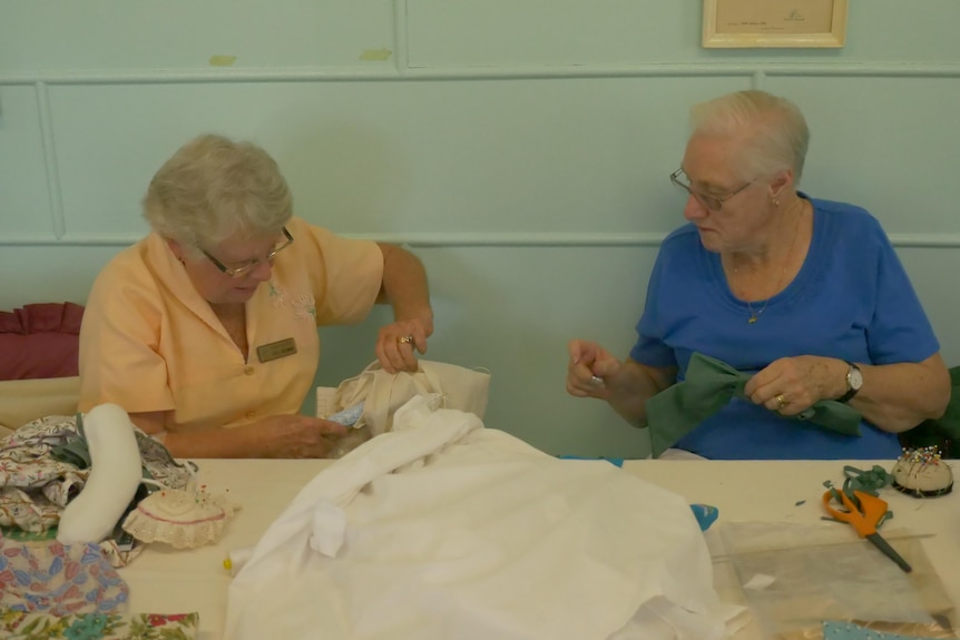 Photo of sewing guild members sitching fabric.