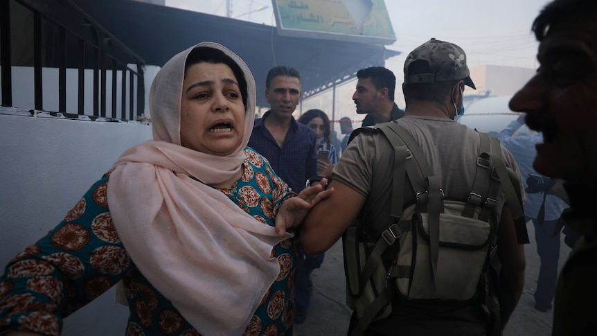 A woman reacts at the site of a car bomb blast in Qamishli, Syria.