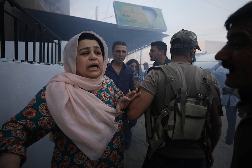 A woman reacts at the site of a car bomb blast in Qamishli, Syria.