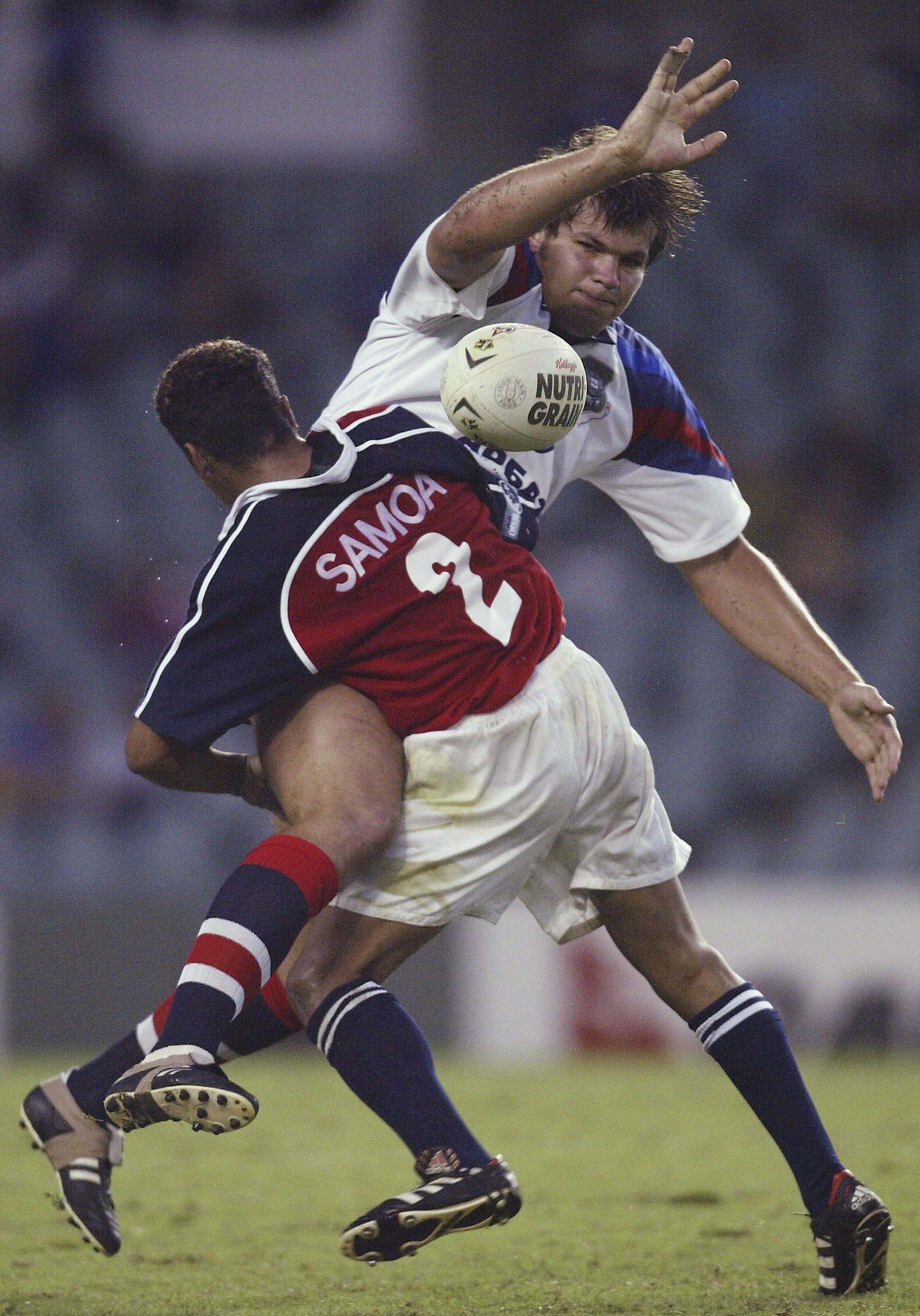 A man offloads during a rugby league match