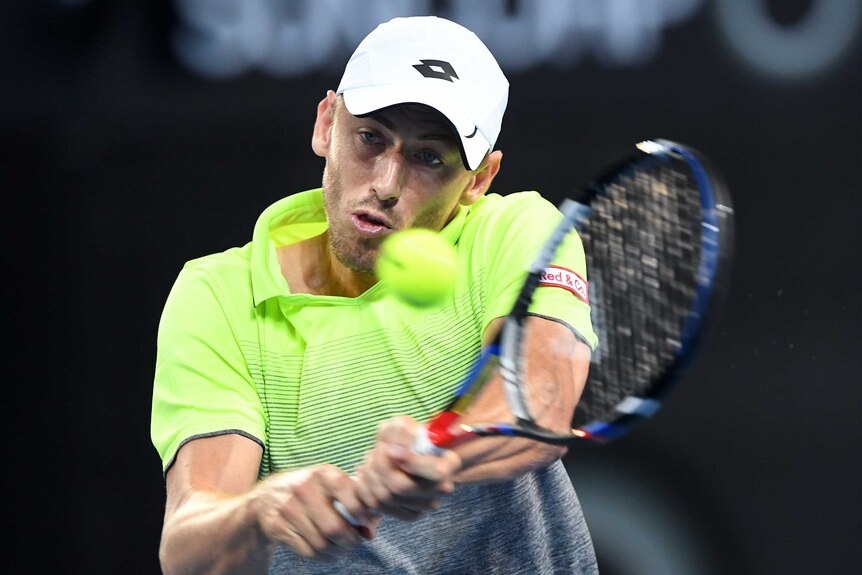 John Millman playing a double-fisted backhand against Peter Polansky at the Brisbane International.