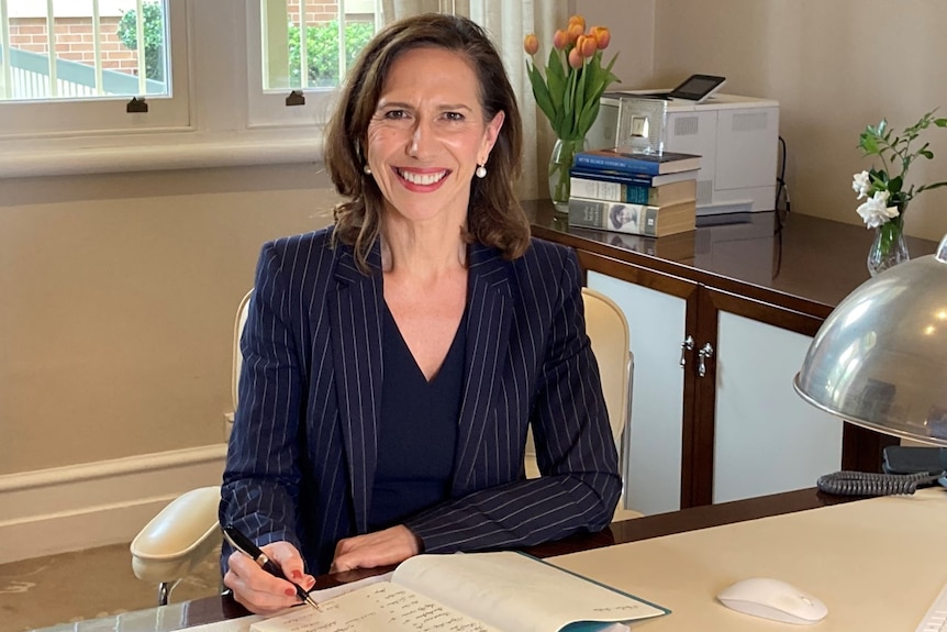 Jacinda smiles at her desk.