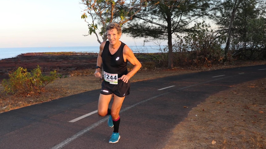 A man in activewear running along a scenic shared path.