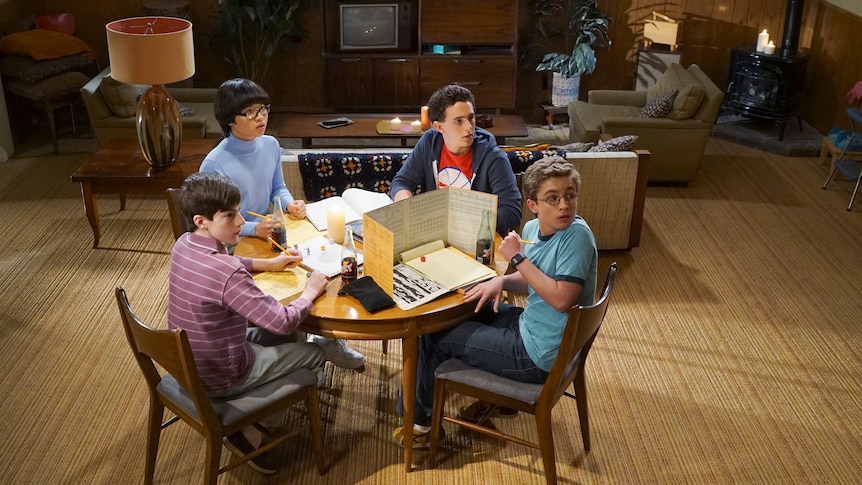 Teenage boys around table playing Dungeons and Dragons, 1980s decor.