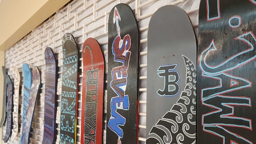 Indigenous students proudly display their painted skateboards