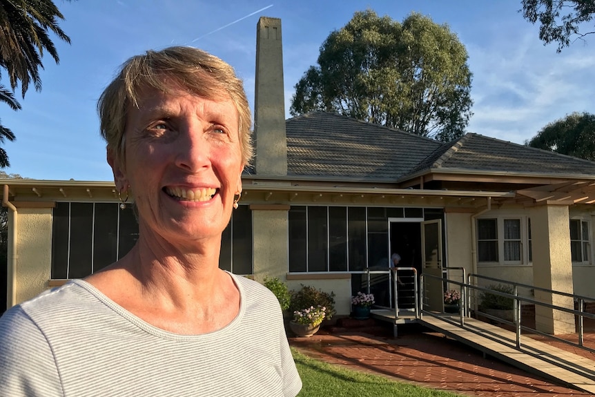 Woman standing in front of a historic homestead