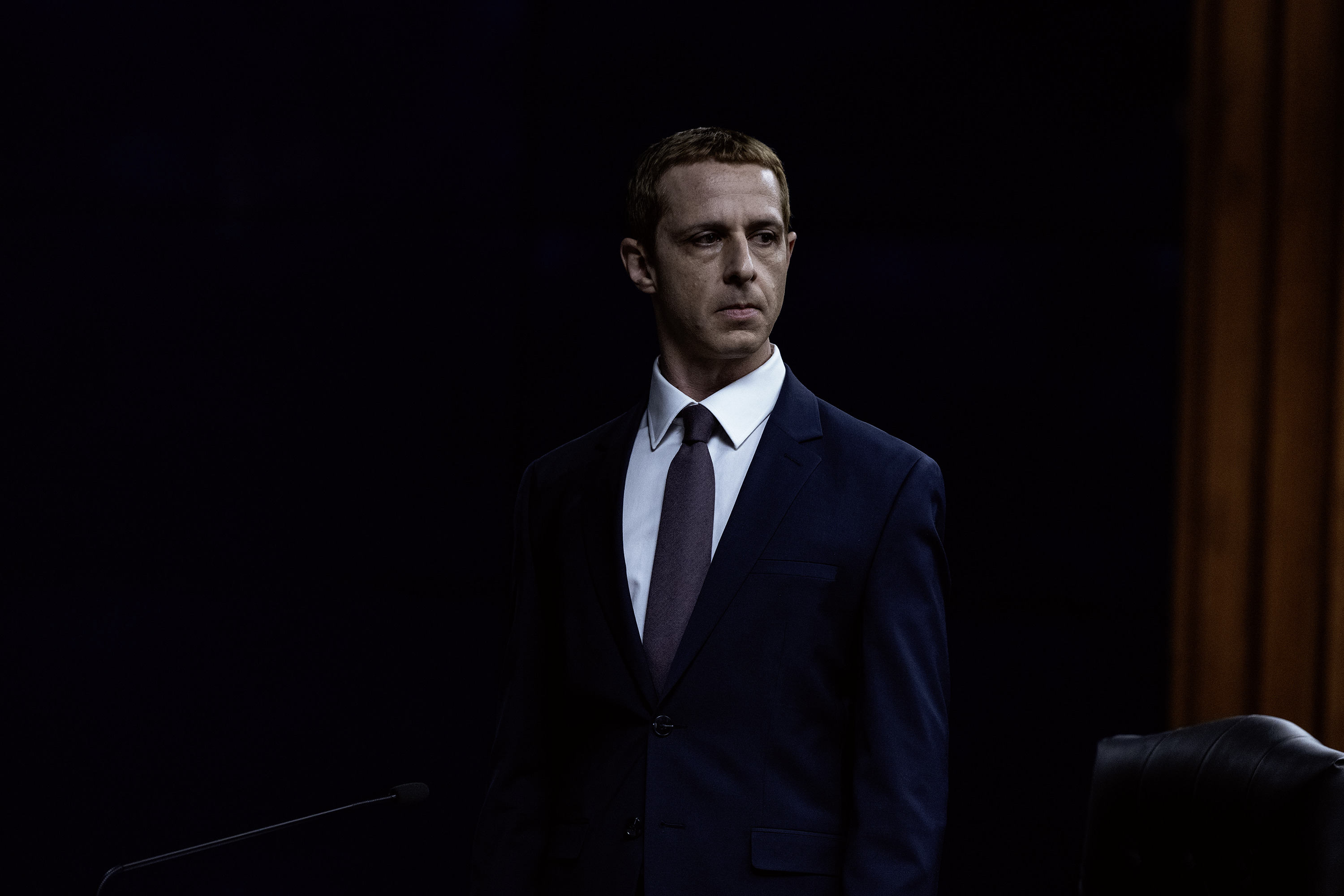 A man in a suit looks off camera