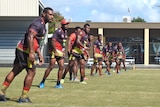 Rugby players line up on field.