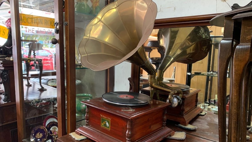 A gramophone sits on an antique dresser.