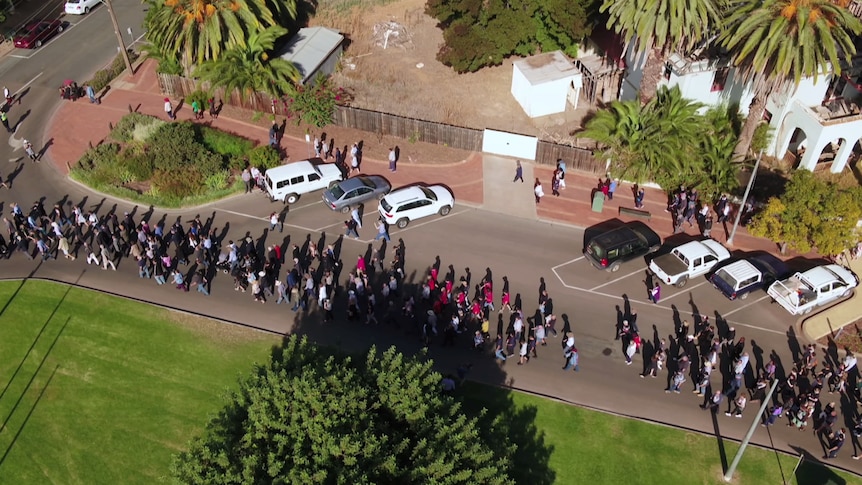 An aerial view of the Anzac Day march where hundreds of Robinvale locals walking together.