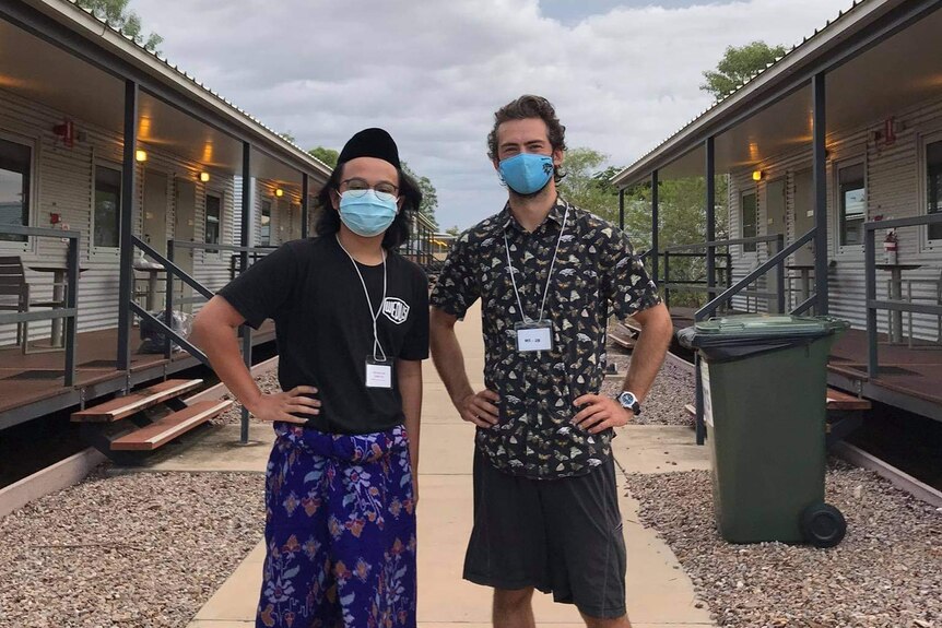 Francois Brassard stands outside with another person, both are wearing masks, at the Howard Springs quarantine facility.