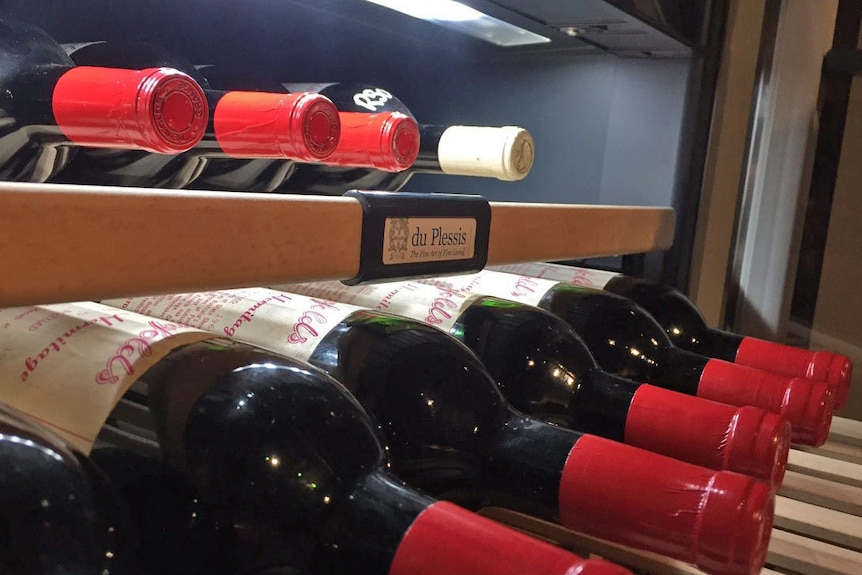 Bottles of Penfolds Grange hermitage wine on a rack.
