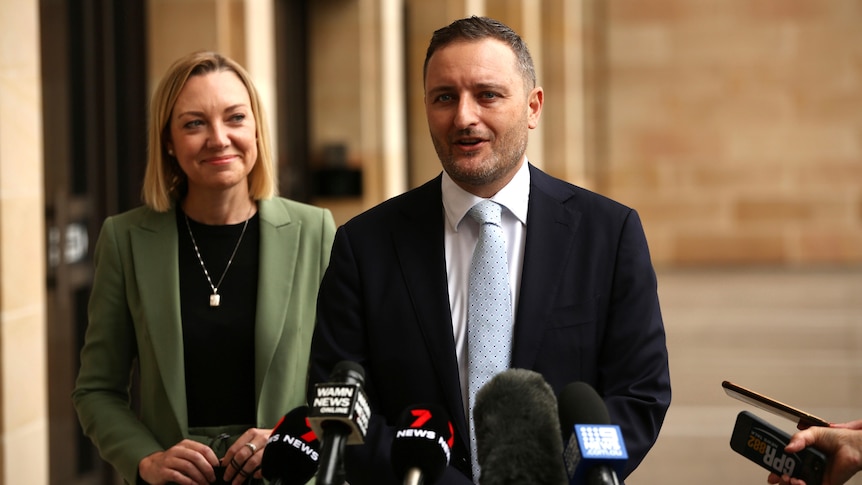 A man and a woman in front of microphones