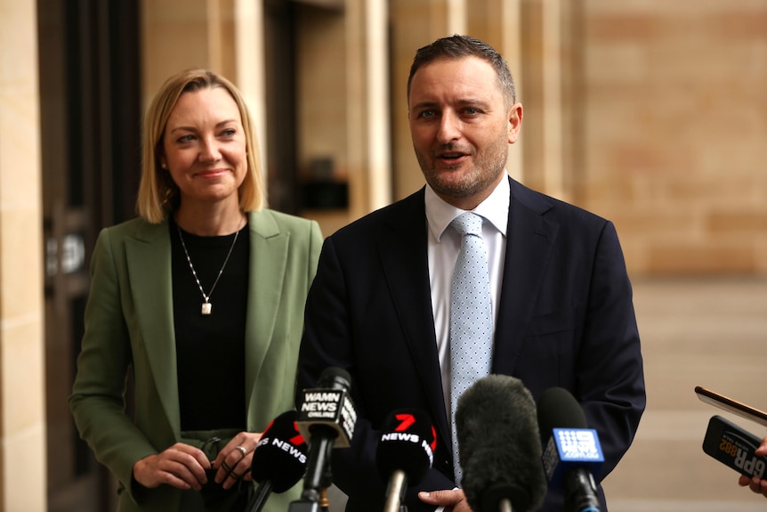 A man and a woman in front of microphones