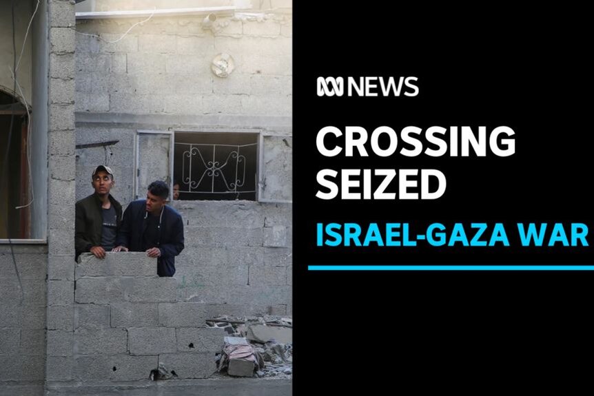Crossing Seized, Israel-Gaza War: Two men stand at the remains of a low wall that has been all-but destroyed.