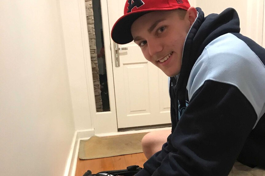 A young baseballer packs his glove in a gym bag