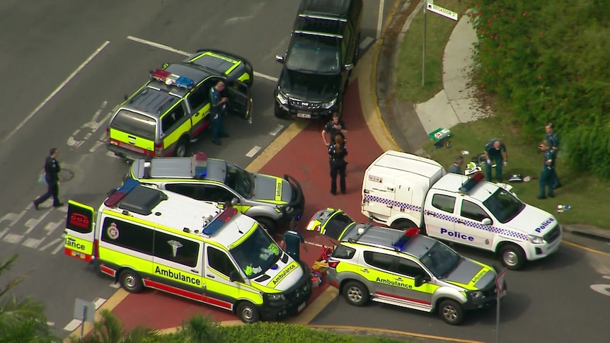 Police and ambulance officers and their vehicles on the scene of a stabbing on Carindale street