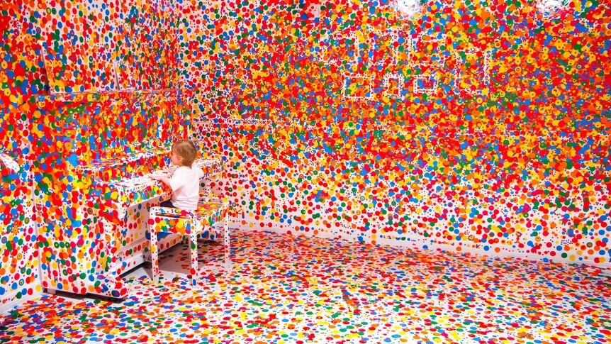 A child plays in Yayoi Kusama’s ‘The obliteration room’ at GoMA in Brisbane.