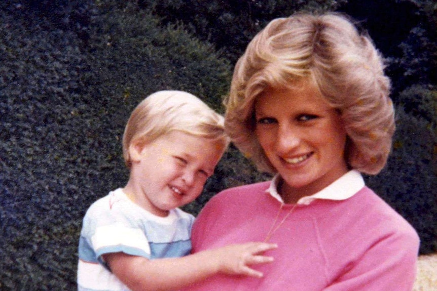Princess Diana holds Prince William whilst pregnant with Prince Harry.