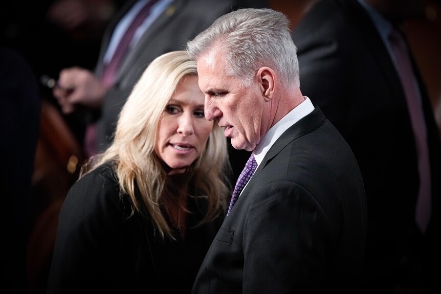 Kevin McCarthy listens to Marjorie Taylor Greene whisper in his ear
