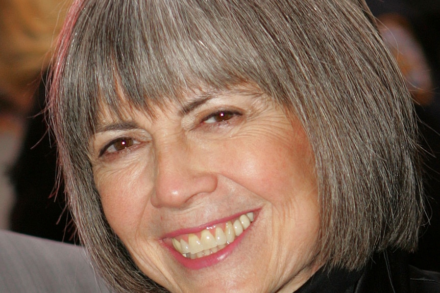 Woman with grey hair smiles.