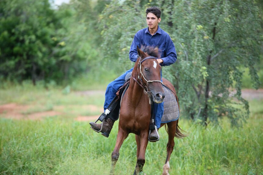 Teenager Mikey Cox rides a horse.