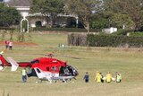 Air ambulance waits for 9-year-old boy to be carried on a stretcher.