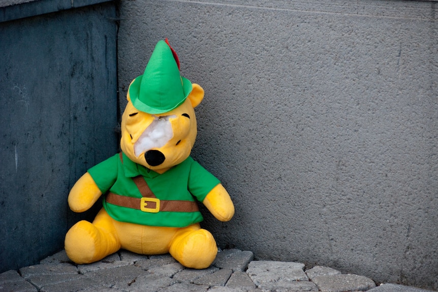 A Winnie the Pooh doll, dressed as Robin Hood.