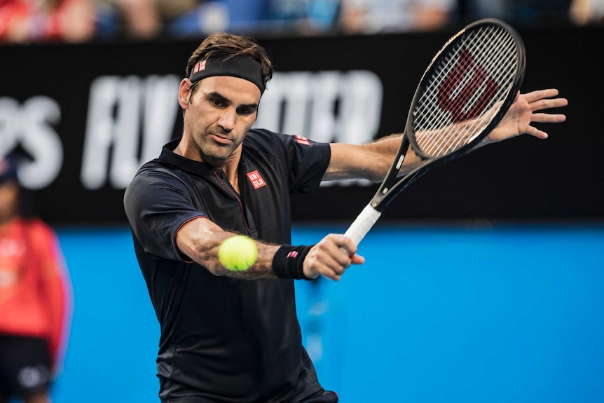 Roger Federer dressed in black hits a backhand shot on court.