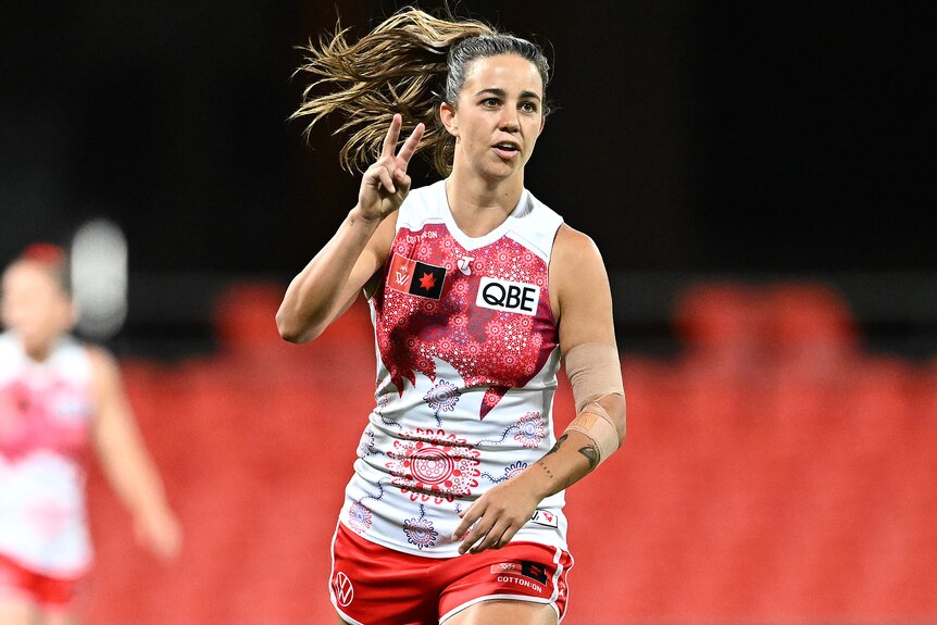 Chloe Molloy raises two fingers to show she had kicked two goals for the Swans in their AFLW elimination final.